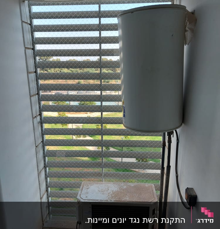 דוד שמש ומזגן ליד רשת הגנה על חלון